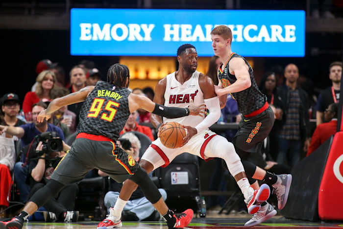 Atlanta Hawks forward DeAndre' Bembry (95) and guard Kevin Huerter (3) defend Miami Heat guard Dwyane Wade.